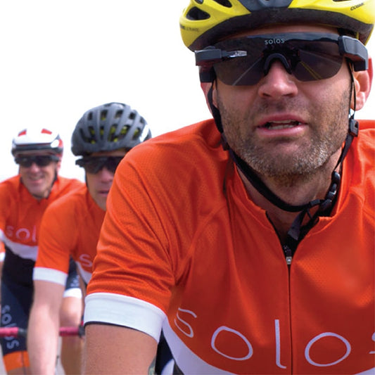 three male cyclists wearing helmets and smart glasses