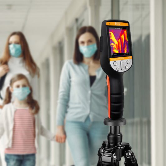Mother and daughter with face mask in front or thermal camera