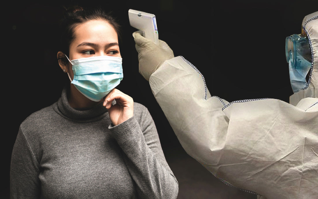 women wearing surgical mask with man in medical protective gear checks her temperature