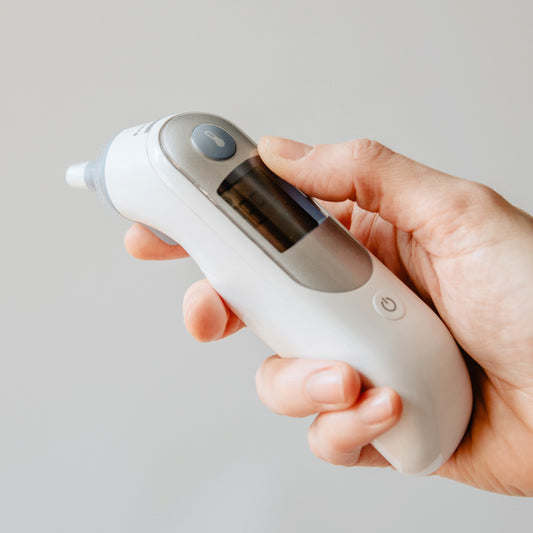 hand holding ear thermometer